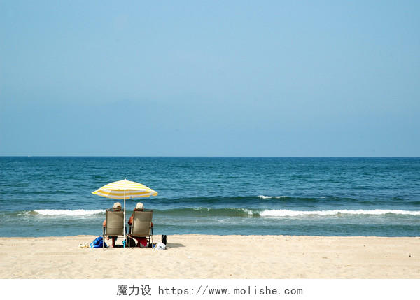 自然风景旅游度假海岸线沙滩太阳伞下的两个人人物图片